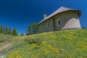 la chapelle sous le soleil derrire partere de fleurs